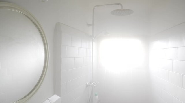Horizontal video of a steamy shower with dense white mist from the start. Water flows softly, with the bathroom barely visible, creating a calm, minimal background atmosphere.