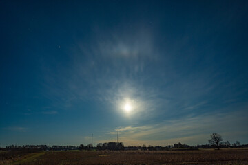 Naklejka premium Moon halo over a quiet rural meadow at night