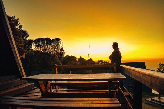 Silhouetted of A lone Climber at the Mountain Cabins at Mandara Hut during sunrise in Montane Forest, Kilimanjaro National Park, Tanzania