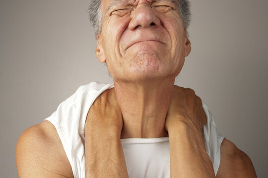 Older Man doing a self-massage on his upper back and shoulders