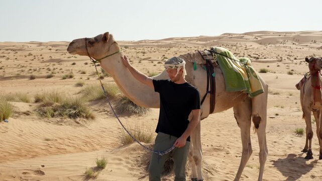 Male Tourist Standing in Front of Camel, Cinematic Travel Encounter in Wahiba Sands Desert Oman