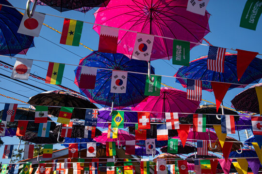 A vibrant display of colorful umbrellas suspended overhead on Isla Bastimentos, creating a lively canopy above a tropical street scene. 