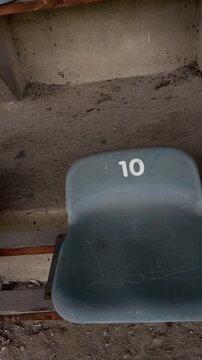 Vacant seating arrangement. Unfilled spectator stands with designated seating spots. Vacant sports arena shows concrete steps with sequentially numbered spectator seats