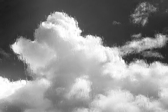 Clouds seen through rain covered window glass close up in black and white monochrome