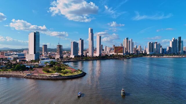 Group of boats stand on the peaceful waterscape. Beautiful modern city skyline in the backdrop. Panama, North America.
