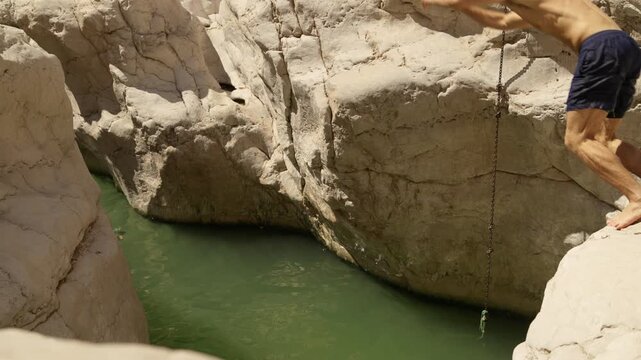 Slow Motion Male Tourist Jumping into Wadi Bani Khalid, Cinematic Cliff Jump in Omani Desert Oasis