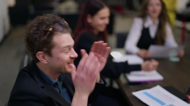 A young business team finds humor and connection during an active discussion. Colleagues share a genuine laugh in a collaborative workplace environment.