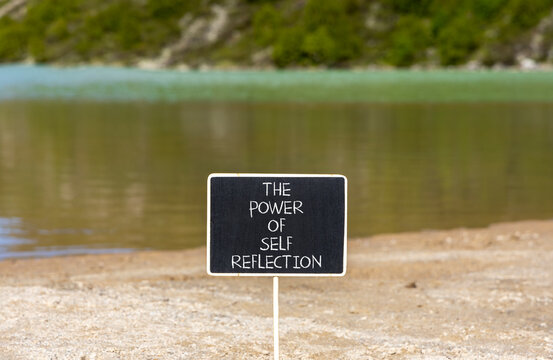 Self reflection symbol. Concept words The power of self reflection on beautiful black blackboard. Beautiful mountain lake background. Business the power of self reflection concept. Copy space.