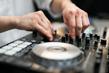 Close-up of DJ hands mixing music on a professional controller © Tsyb Oleh