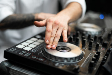 Close-up of DJ hands mixing music on a professional controller © Tsyb Oleh