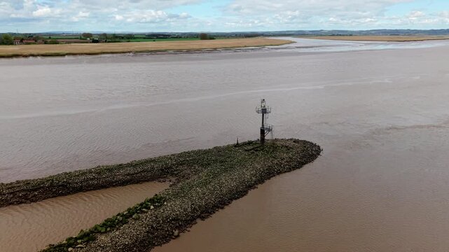 Aerial view of Trent Falls showing the stone breakwater and navigation beacon at the river confluence under a cloudy sky in Goole, United Kingdom.