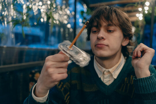 Analog audio nostalgia young man rewinding cassette tape with pencil, showing tactile music ritual, predigital listening habits, vintage technology and lofi culture.
