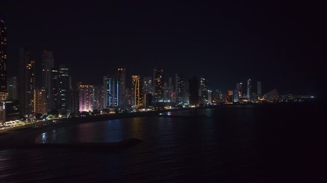 Night view of Bocagrande in Cartagena, Colombia, featuring illuminated buildings and skyline along the Caribbean coast. Urban coastal scene with city lights and modern architecture.