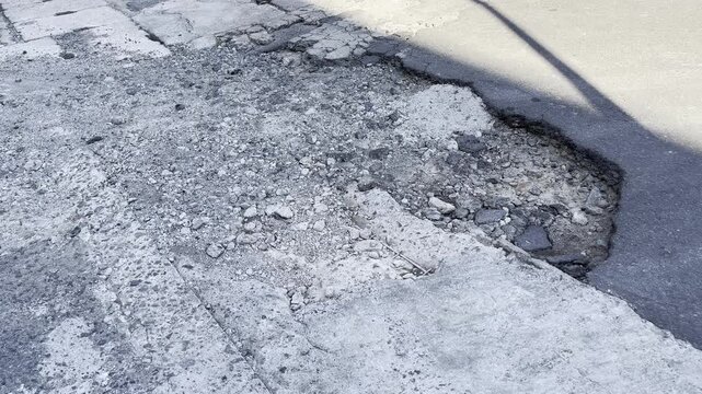Large Pothole on Damaged Asphalt Road Surface