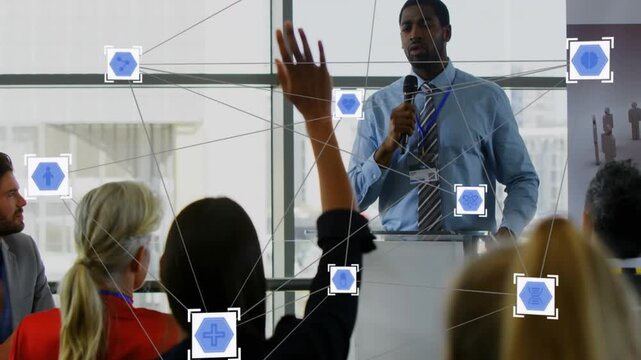 Host at clear lectern talking as woman raising hand asking, nodes forming linking business team