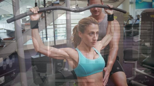Trainer hand cueing as trainee pulling pulldown bar down, returning up, repeating to build back