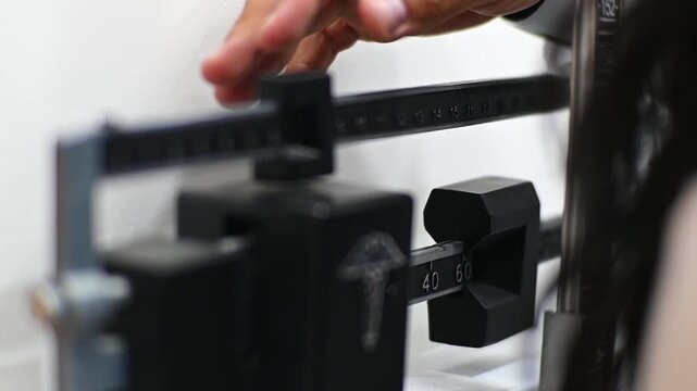 1080p 60fps horizontal video of a doctor weighing his patient on his scale, both of Latino origin
