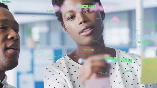 Lead woman holding note and talking writing on glass while planning crypto tickers overlaying glass