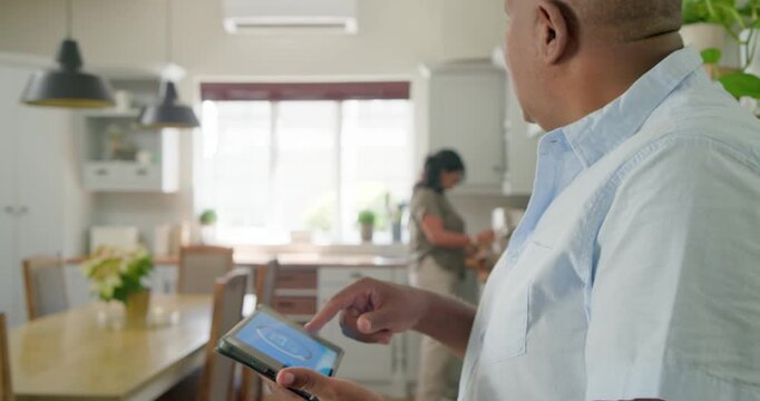 African American couple man tapping tablet climate adjusting temp while woman prepping, copy space