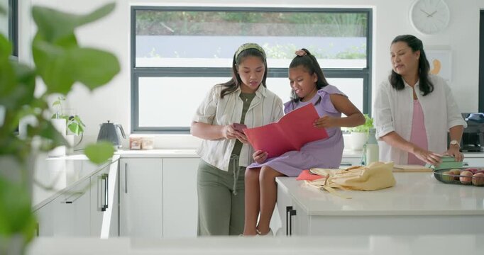 Diverse family noticing red folder, parents and youth sharing it on kitchen island packing lunch