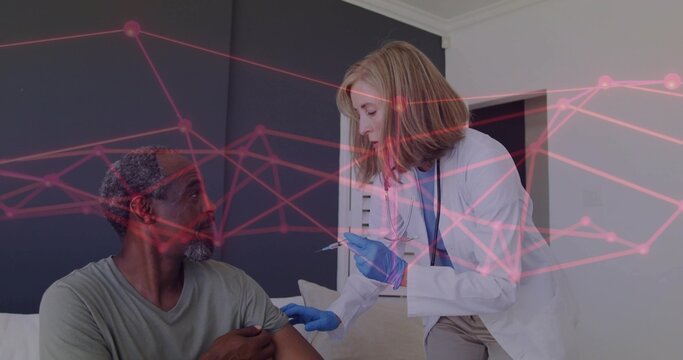 Leaning clinician in white lab coat, blue gloves holding syringe by patient at home, pink overlay