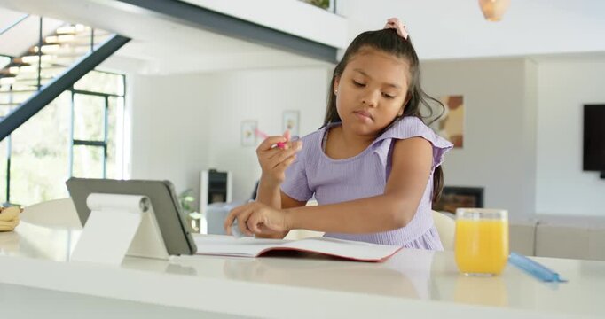 African American family girl handling blue eraser, writing in notebook with pink pencil and waving