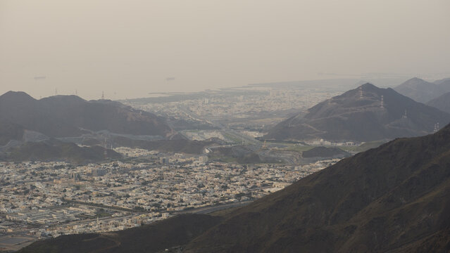 Aerial view of  city from mountain with grass foreground in UAE, Khor fakkan Sharjah