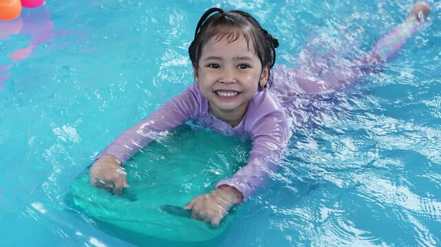 slow motion of preschool child girl playing in portable swimming pool in backyard at home