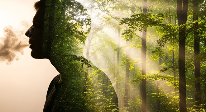 Double exposure of man exhaling smoke superimposed on a vibrant green forest with sunbeams