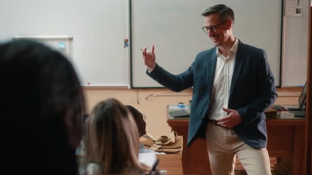 Smiling professor receiving applause from students after successful university lecture, thanking class for attention and engagement in positive academic atmosphere.