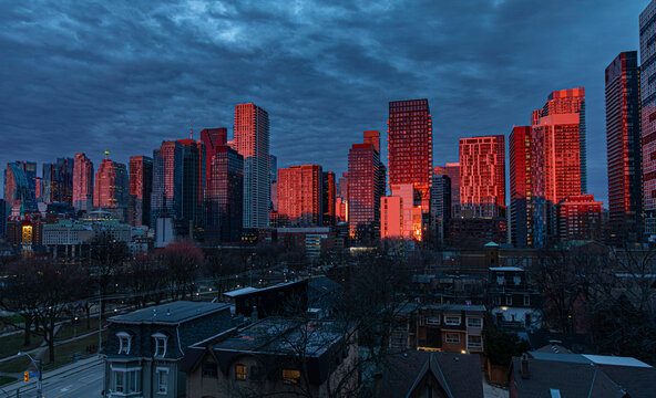 Newly completed condos and other downtown Toronto buildings glow fiery red in the dawn sunlight.
