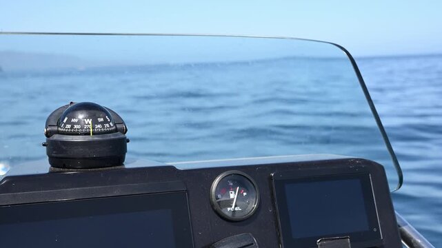 Boat compass and gas gauge on ocean.