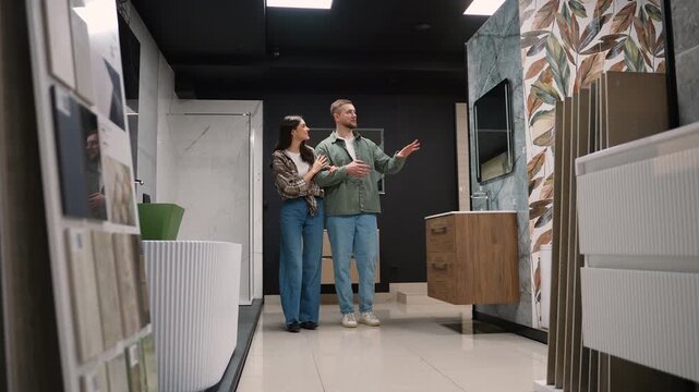 Young couple choosing bathroom furniture in showroom