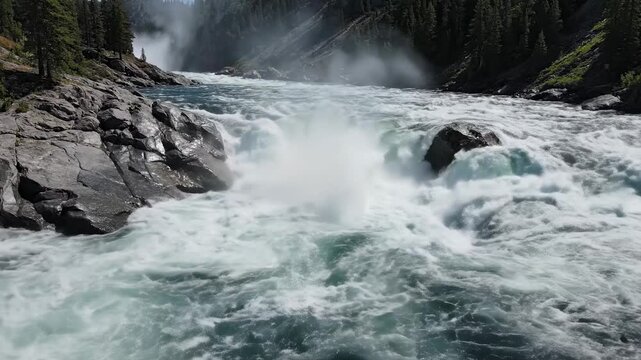This captures the breathtaking beauty of a waterfall in a natural setting. The rushing water creates a misty atmosphere, surrounded by lush greenery and rocky terrain, evoking a sense of serenity and