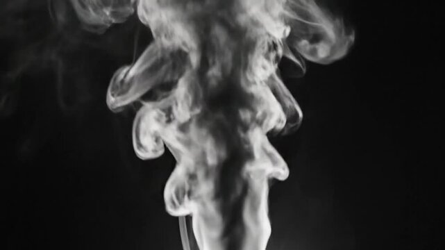 Abstract slow motion of rising swirling smoke in shades of grey against a black background