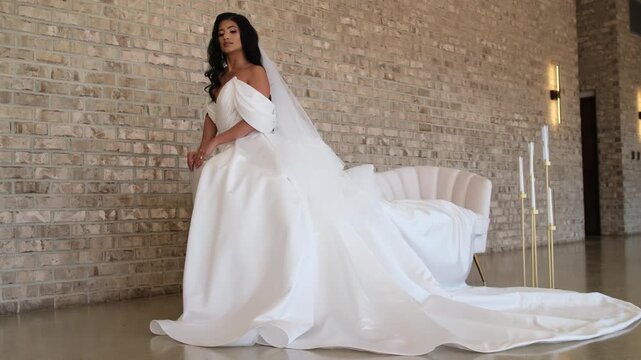 Beautiful bride wearing white wedding dress posing indoors
