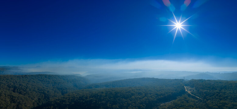 Bushfire smoke and a vibrant sparkling rising sun in a valley near the town of Lawson in the Blue Mountains in New South Wales, Australia