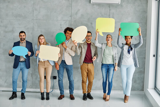 Portrait of a group of young business people in office. Speech bubble, team and comment by business people holding sign, news and voice icon feeling excited on social media. Group, opinion and poll by
