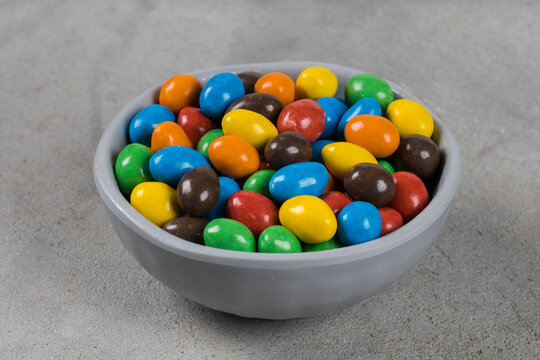 MultiColored Candies, Dragees with peanuts and chocolate. In a bowl. Light gray background. Close-up		