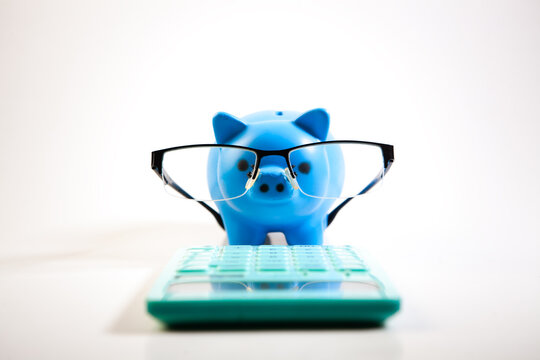 piggy bank on a laptop, glasses and calculator