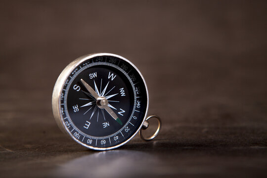 old compass on a black background with the shadow of the compass, the concept of tourism, compass, travel.
