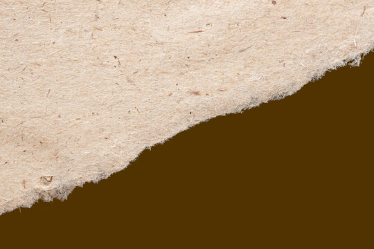 Torn paper texture background with rough edge on natural fiber sheet on brown backdrop creating contrast, layout use. Natural background with paper texture, torn edge, copy space