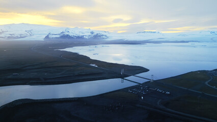 Aerial view of arctic black sand beach in iceland, nordic ocean shore landscape with snowy mountains. Spectacular icelandic scenery with scenic route on atlantic coastline. Slow motion. © DC Studio