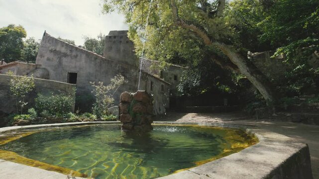 Water flowing from an ancient stone fountain in a monastery garden