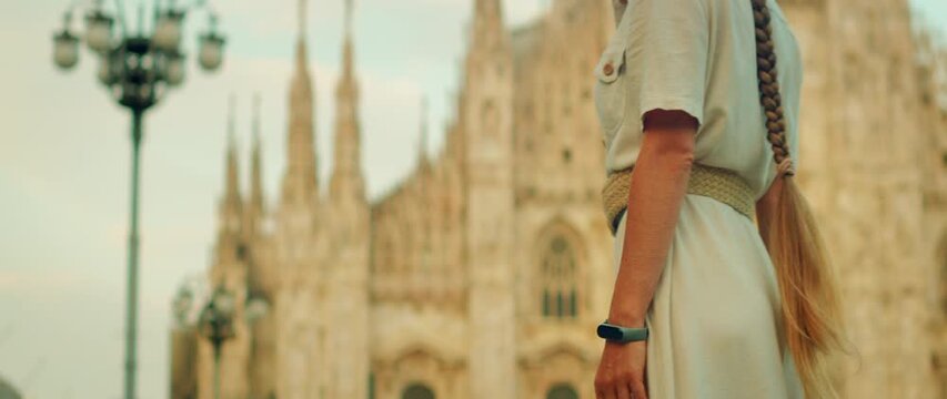 Tourist stands in front of Milan Cathedral in Piazza del Duomo during daytime visit