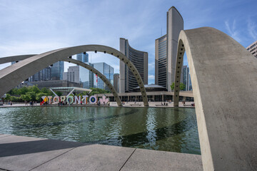 Naklejka premium Nathan Phillips Square Freedom Arches with Toronto City Hall and Toronto Sign - Toronto, Ontario, Canada