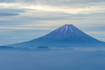 Fototapeta premium Mystical dawn landscape of Mount Fuji and foggy Kofu Basin in early summer from Mount Amari, Yamanashi, Japan.