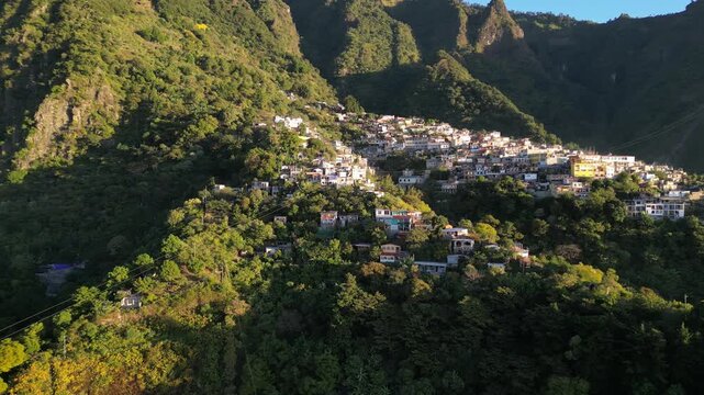 historic mayan village in lake atitlan guatemala (santa cruz la laguna) small homes maya residents side of mountain volcanic caldera volcano travel tourism poverty traditional native aerial