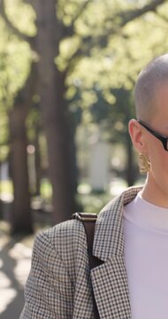 Businesswoman, walk and commute in park with phone call, conversation or feedback for real estate job. Happy, female person and realtor talk outdoor with tech, contact and glasses for travel to work.