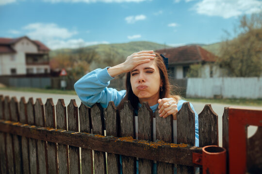 Curious Neighbor Picking over the Fence with a Frustrated Expression. Stressful nosy woman watching her neighbors in disbelief 
